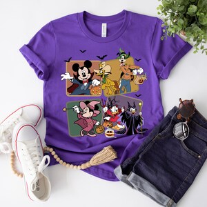 K&ouml;nnte beinhalten: Lilafarbenes T-Shirt mit einem Motiv von Mickey Mouse, Goofy, Donald Duck und Maleficent, die sich f&uuml;r Halloween verkleidet haben. Die Figuren halten K&uuml;rbisse und S&uuml;&szlig;igkeiten.
