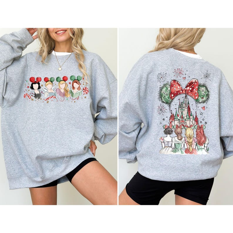 May include: A light gray sweatshirt featuring a festive design. The front displays four cartoon characters with holiday-themed mouse ears. The back showcases a castle scene with a large red bow and mouse ears. The sweatshirt is paired with black shorts.