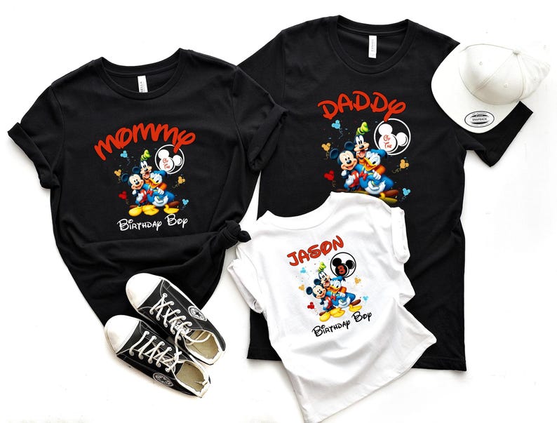 May include: Black t-shirts with Mickey Mouse, Donald Duck, and Goofy graphics. One shirt says "Mommy Birthday Boy", another says "Daddy & Two", and the third says "Jason Birthday Boy". A white baseball cap and black sneakers are also in the image.
