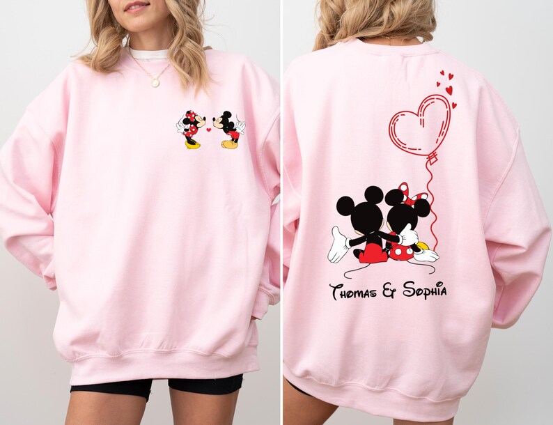 May include: Pink sweatshirt with a graphic of Mickey and Minnie Mouse kissing on the front and a heart with the text "Thomas & Sophia" on the back.