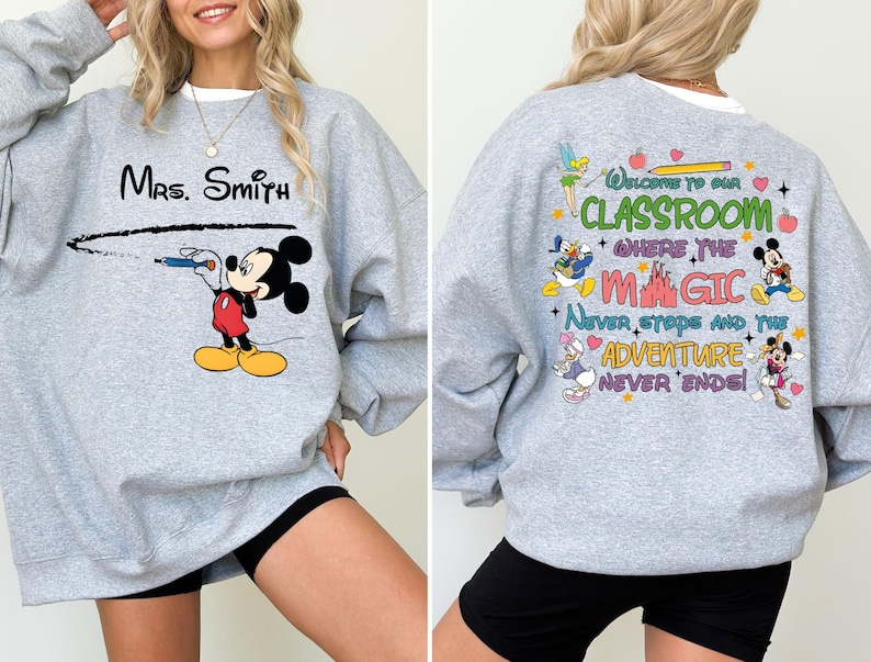 May include: Gray sweatshirt with a Mickey Mouse design on the front and a Disney-themed quote on the back. The quote reads "Welcome to our classroom where the magic never stops and the adventure never ends!"