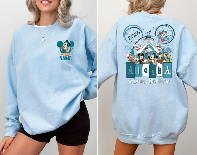 May include: Light blue sweatshirt with a Mickey Mouse graphic and the text "Alaska Disney Wonder" on the front. The sweatshirt has a crew neck and long sleeves.