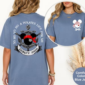 May include: Blue jean-colored t-shirt with a pirate-themed graphic. The design features an anchor, Mickey Mouse ears with a red bandana, and the text "Yo Ho Ho A Pirates Life For Me Disney 2026". A smaller pirate Mickey Mouse graphic is on the front.