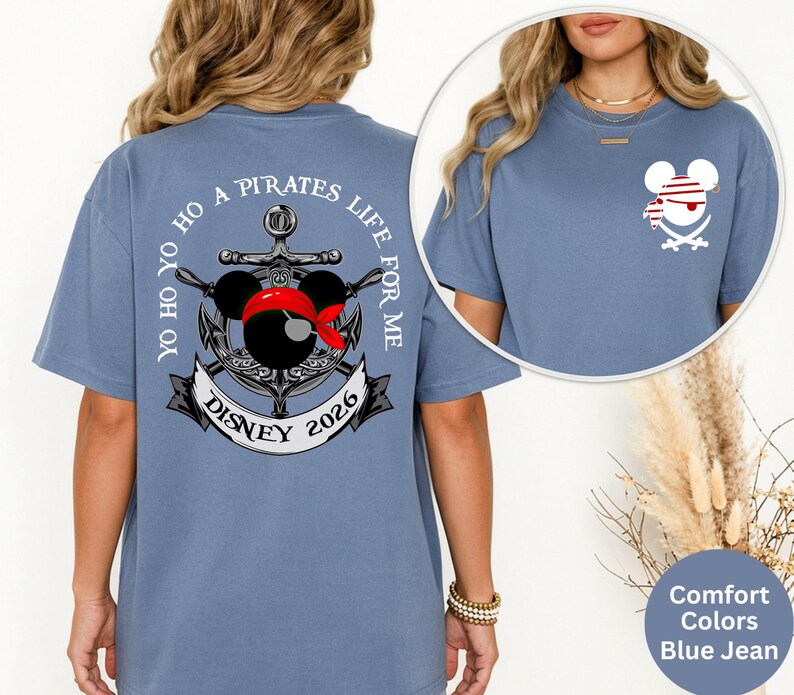 May include: Blue jean-colored t-shirt with a pirate-themed graphic. The design features an anchor, Mickey Mouse ears with a red bandana, and the text "Yo Ho Ho A Pirates Life For Me Disney 2026". A smaller pirate Mickey Mouse graphic is on the front.