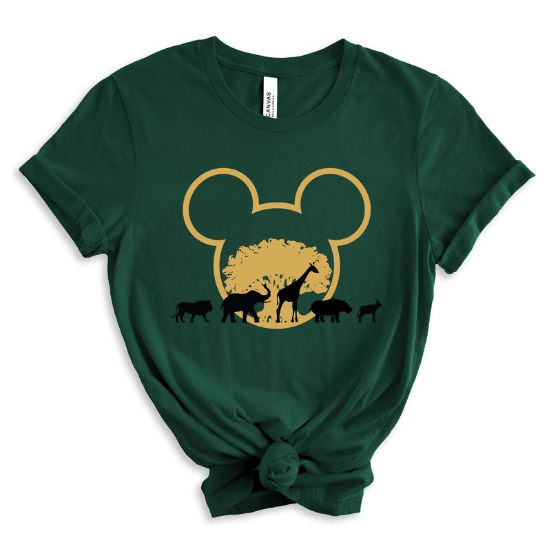 May include: Green t-shirt with a gold Mickey Mouse head silhouette. Inside the silhouette is a gold tree with black silhouettes of a lion, elephant, giraffe, hippopotamus, and zebra.