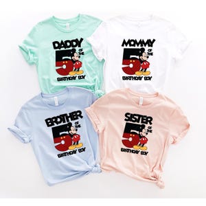 Puede incluir: Cuatro camisetas de manga corta en colores pastel: verde menta, blanco, azul claro y melocot&oacute;n. Cada camiseta presenta un gr&aacute;fico de Mickey Mouse con el n&uacute;mero 5 y las palabras "Daddy", "Mommy", "Brother" o "Sister" y "Birthday Boy".