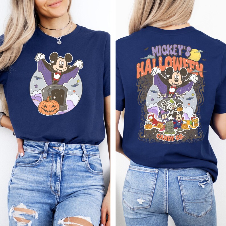 May include: A navy blue t-shirt featuring a Mickey Mouse Halloween graphic. The front of the shirt shows Mickey Mouse dressed as a vampire with a pumpkin. The back of the shirt depicts Mickey Mouse and his friends in Halloween costumes with the text "Mickey's Halloween" and "Candy Co."
