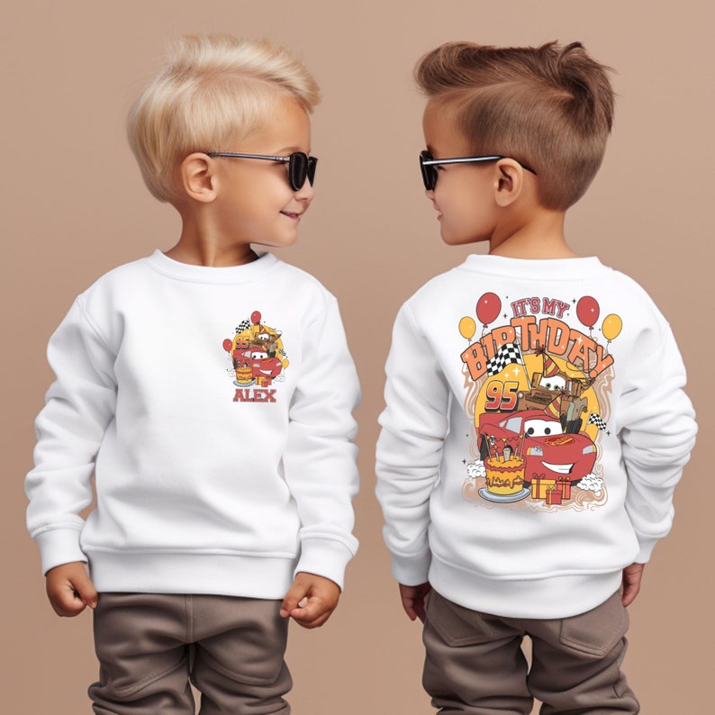 Puede incluir: Sudadera blanca con un coche rojo de dibujos animados y el texto "It's My Birthday 95" en la espalda. La parte delantera de la sudadera tiene una imagen m&aacute;s peque&ntilde;a del coche y el nombre "Alex".