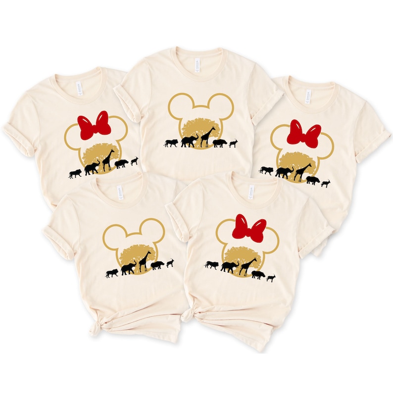 May include: Set of five beige t-shirts with a gold Mickey Mouse head silhouette and a red bow. Each shirt features a silhouette of a giraffe, elephant, lion, zebra, and rhino.