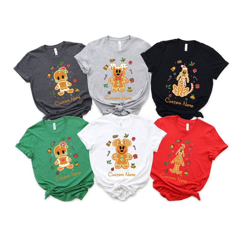 May include: Five different colored t-shirts with a gingerbread man design. The shirts are green, white, gray, black, and red. Each shirt has a different gingerbread man design with the text "Custom Name" on the bottom.