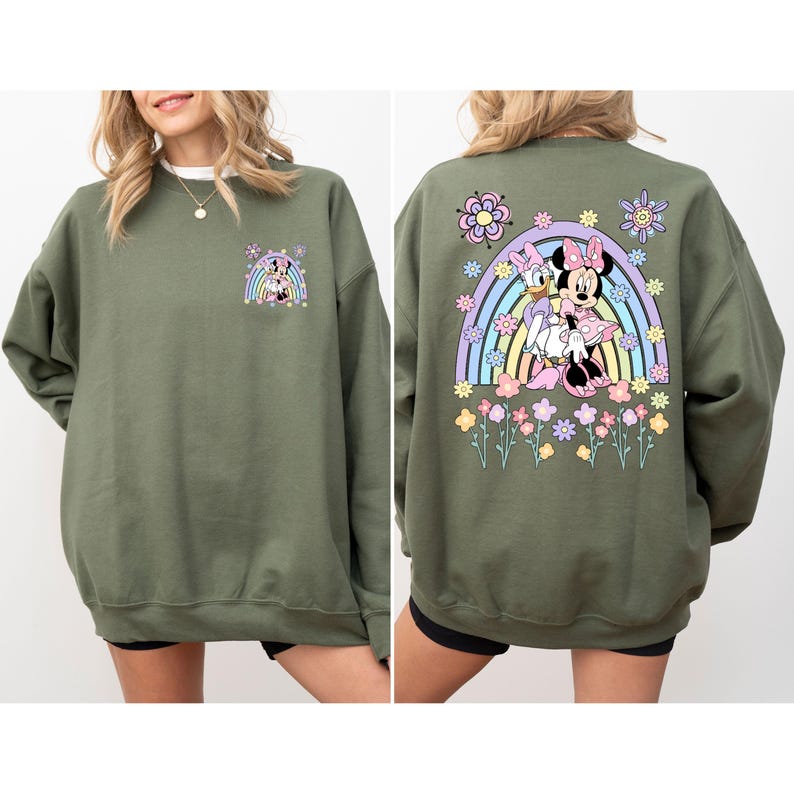 May include: A green sweatshirt with a cartoon image of Minnie Mouse and Daisy Duck on the back. The image features a rainbow and flowers. The front of the sweatshirt has a smaller image of Minnie Mouse and Daisy Duck.