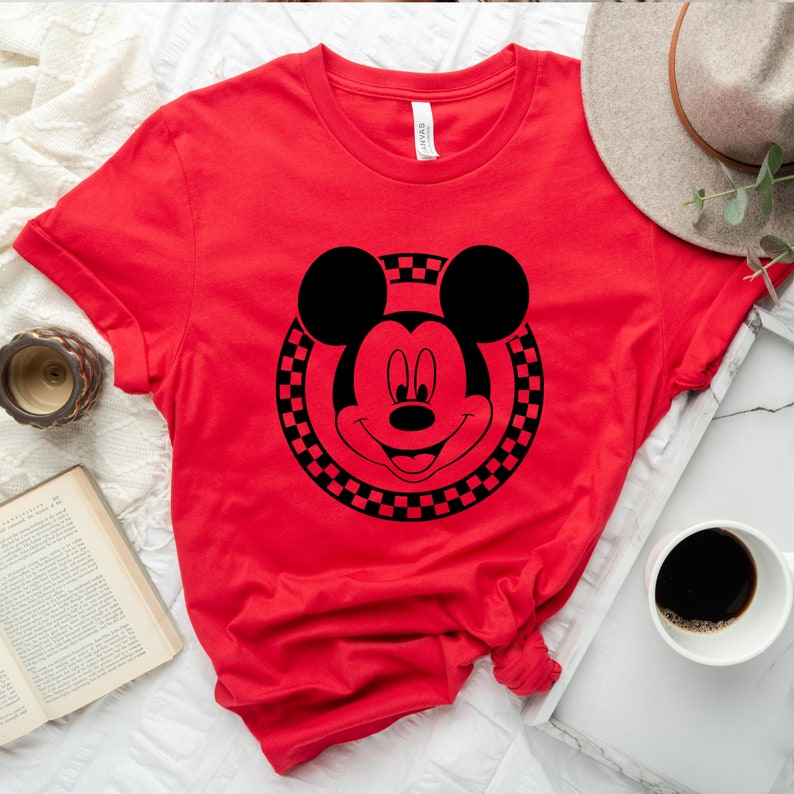 May include: Red t-shirt with a black and white chequered circle around a black Mickey Mouse head.