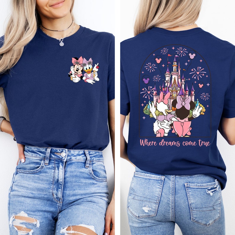 Pu&ograve; includere: Una maglietta blu navy con una grafica di Topolino e Minnie Mouse davanti al Castello di Cenerentola. La parte posteriore della maglietta ha una grafica pi&ugrave; grande del castello con fuochi d'artificio e il testo "Where dreams come true".