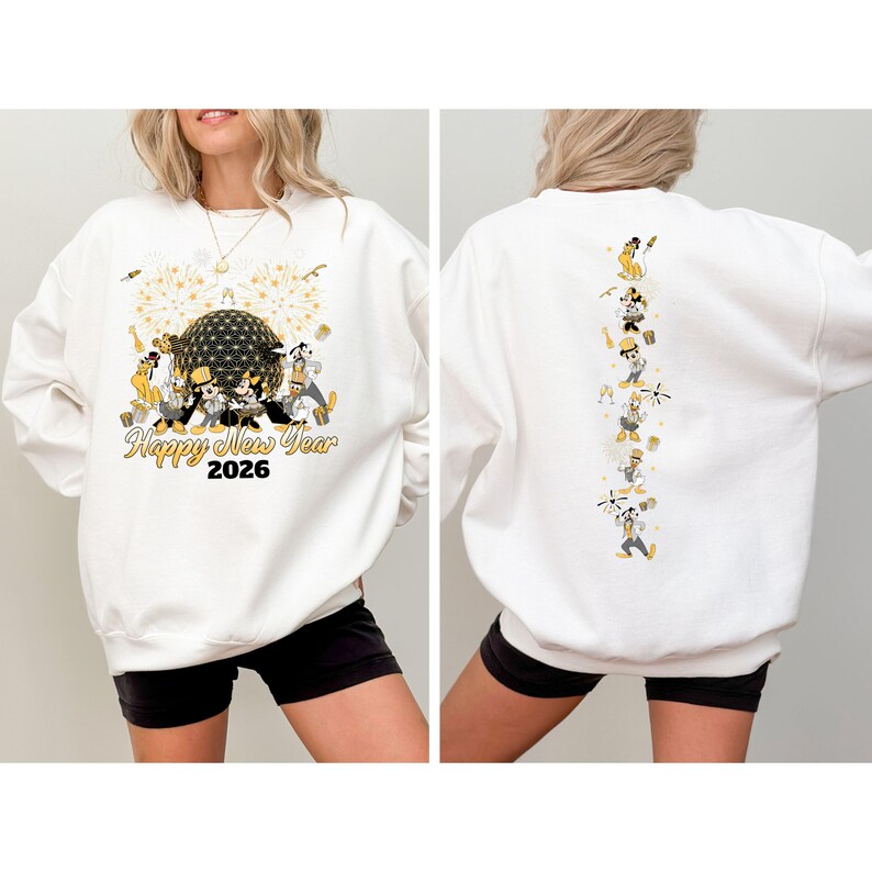 May include: White sweatshirt with a festive design for the New Year 2026. The front features a gold and black graphic with fireworks and cartoon characters. The back has a vertical line of cartoon characters in celebratory poses.