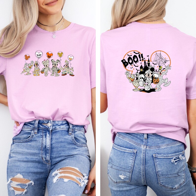 K&ouml;nnte beinhalten: Hellrosa T-Shirt mit Halloween-Motiven. Auf der Vorderseite sind Cartoon-Figuren als Mumien mit Luftballons abgebildet. Auf der R&uuml;ckseite befinden sich ein Schloss, Spinnweben und der Schriftzug "BOO!!" in Schwarz.