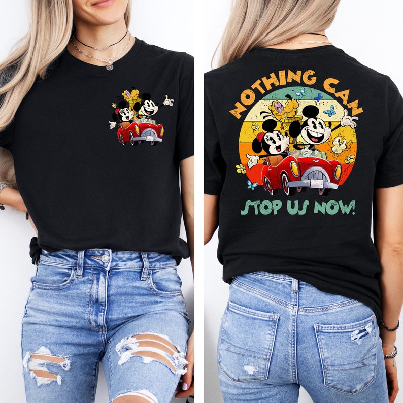 May include: A black t-shirt with a vintage-style graphic of Mickey Mouse, Minnie Mouse, and Pluto driving a red car. The graphic is surrounded by a circle with the text 'NOTHING CAN STOP US NOW!' in a colorful retro font.