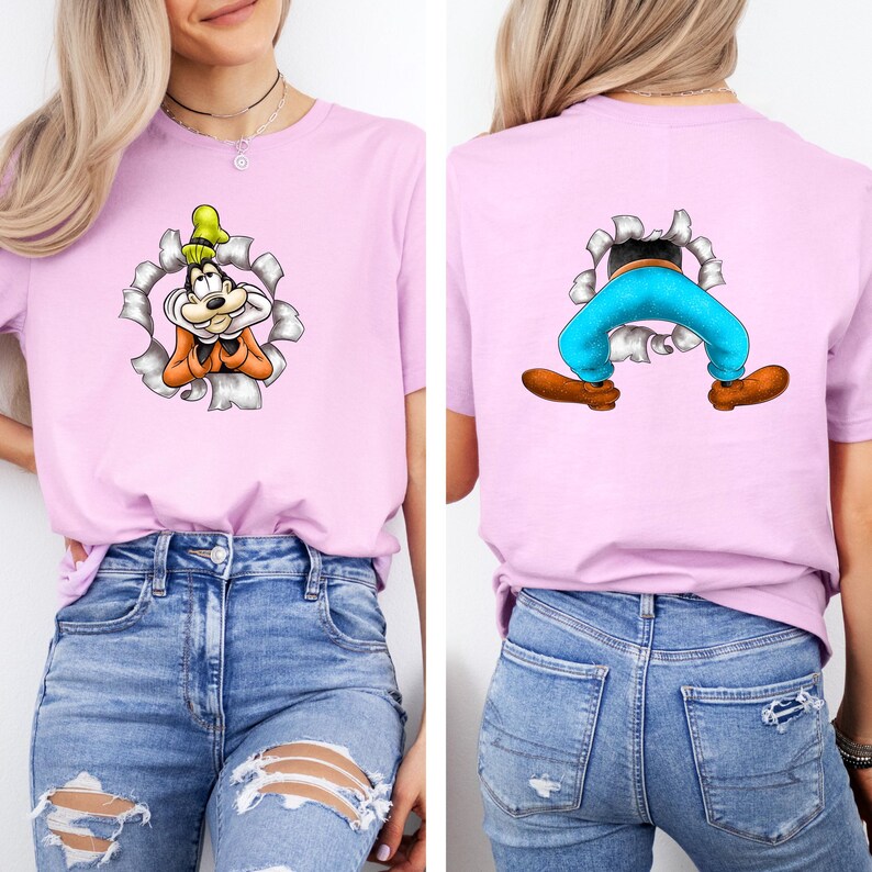 K&ouml;nnte beinhalten: Hellrosa T-Shirt mit einem Cartoon-Charakter-Design. Auf der Vorderseite des T-Shirts ist das Gesicht der Figur zu sehen, das aus einem zerrissenen Loch herausragt, w&auml;hrend die R&uuml;ckseite die Beine und F&uuml;&szlig;e der Figur zeigt. Die Figur tr&auml;gt einen Hut, ein orangefarbenes Hemd und eine blaue Hose.
