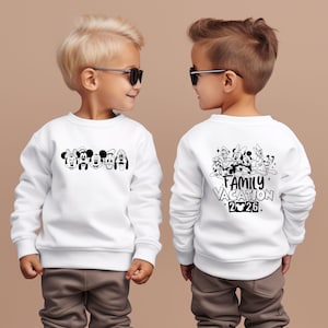 May include: White sweatshirt featuring a black and white graphic of Disney characters on the front and back. The front displays character faces, while the back says "Family Vacation 2026". The sweatshirt is worn by a child.