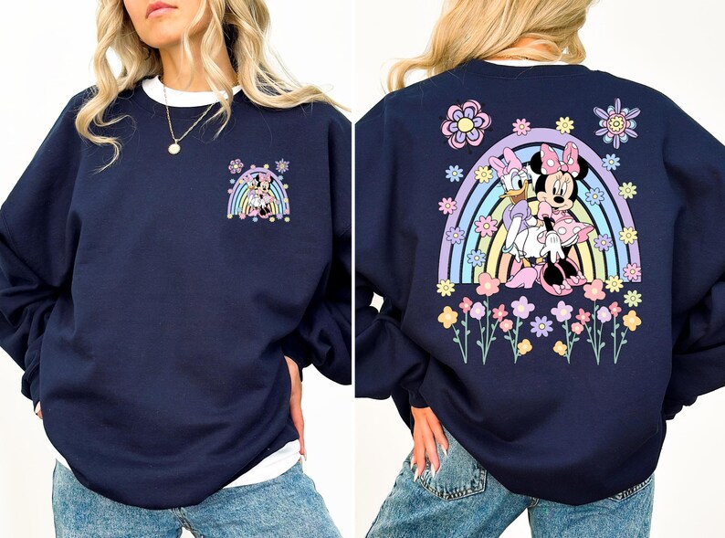 May include: A navy blue sweatshirt with a rainbow and flower design featuring Minnie Mouse and Daisy Duck. The design is on the back of the sweatshirt. The front of the sweatshirt has a smaller design of Minnie Mouse and Daisy Duck.