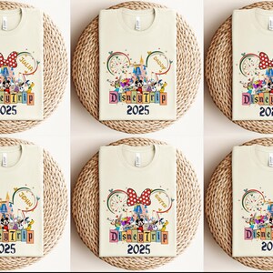 May include: Six cream-colored t-shirts with a colorful Disney-themed design. The design features Mickey Mouse, Minnie Mouse, and other Disney characters. The text "DisneyTrip 2025" is printed on each shirt. The shirts are arranged in two rows of three.