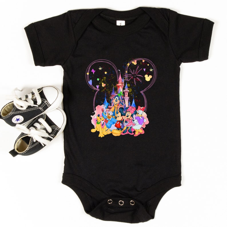 May include: Black baby onesie with a colorful graphic of Mickey Mouse and friends in front of Cinderella's Castle. The graphic is surrounded by a pink Mickey Mouse ear outline.