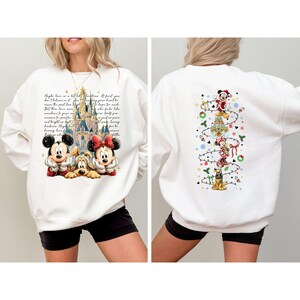 Puede incluir: Sudadera blanca con Mickey y Minnie Mouse frente a un castillo y texto. La parte trasera de la sudadera tiene un dise&ntilde;o navide&ntilde;o con Mickey y Minnie Mouse y Pluto.