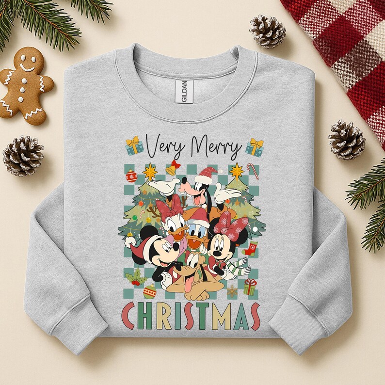 May include: A light gray sweatshirt featuring a colorful graphic of Disney characters, including Mickey and Minnie Mouse, Donald Duck, and Goofy, in Santa hats. The words "Very Merry Christmas" are printed on the front, with Christmas tree and gift box accents.