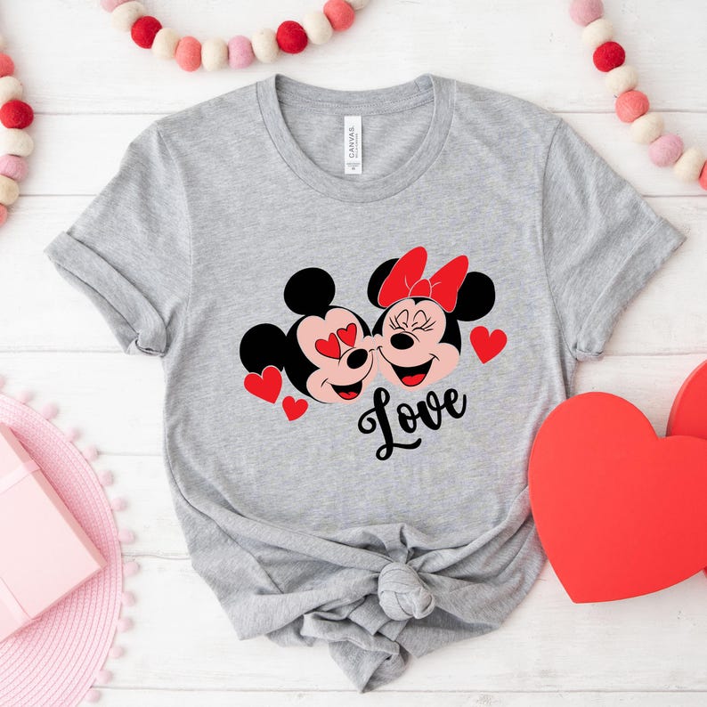 May include: Gray t-shirt with a graphic of Mickey Mouse and Minnie Mouse with red hearts and the word "Love" printed on the front.