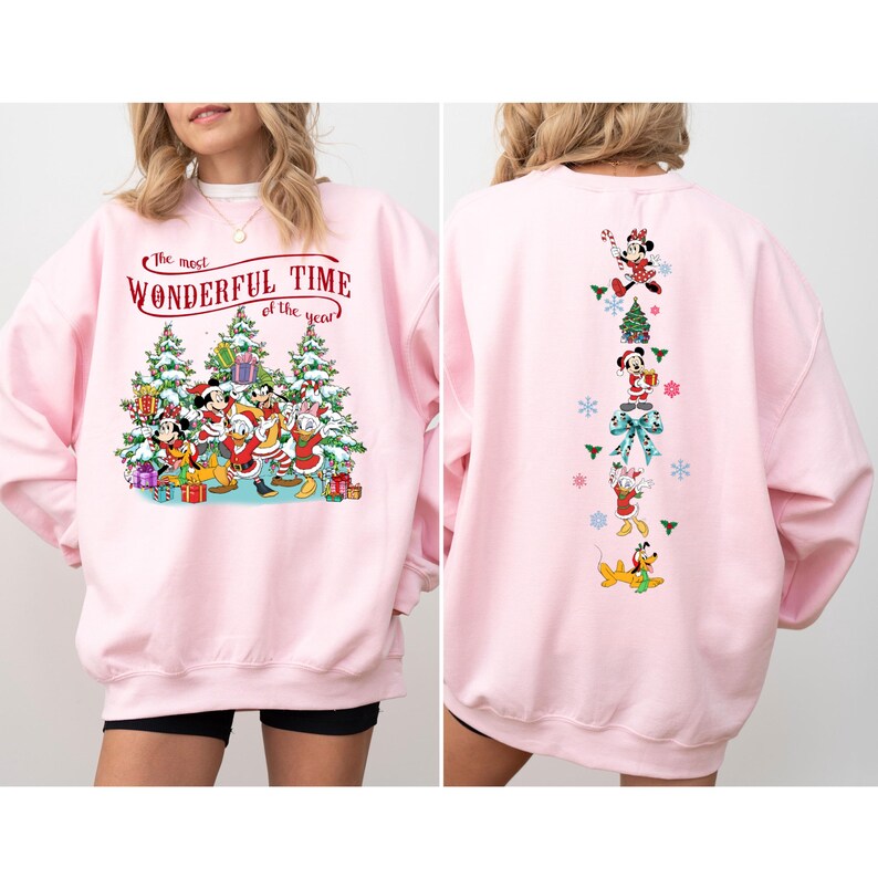 Puede incluir: Sudadera rosa claro con dise&ntilde;o navide&ntilde;o. La parte delantera muestra a Mickey Mouse, el Pato Donald y amigos con el texto "The most Wonderful Time of the year". La parte trasera presenta un dise&ntilde;o vertical de personajes de Disney.