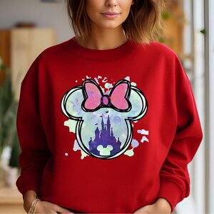 May include: Red sweatshirt with a watercolor-style graphic of Mickey Mouse's head with a bow and Cinderella's castle inside.