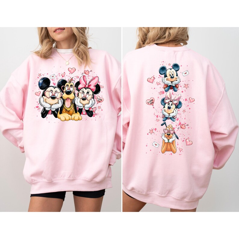 May include: A light pink sweatshirt featuring Mickey Mouse, Minnie Mouse, and Pluto. The front graphic shows the characters together, while the back has individual images of them with hearts and the words "I Love You."