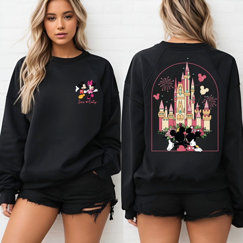 K&ouml;nnte beinhalten: Schwarzer Pullover mit einem Mickey Mouse und Minnie Mouse Motiv auf der Vorderseite und einem Motiv von Schloss Aschenputtel mit Mickey Mouse und Minnie Mouse auf der R&uuml;ckseite. Der Text "Jack & Emily" ist unter dem Mickey Mouse und Minnie Mouse Motiv auf der Vorderseite gedruckt.