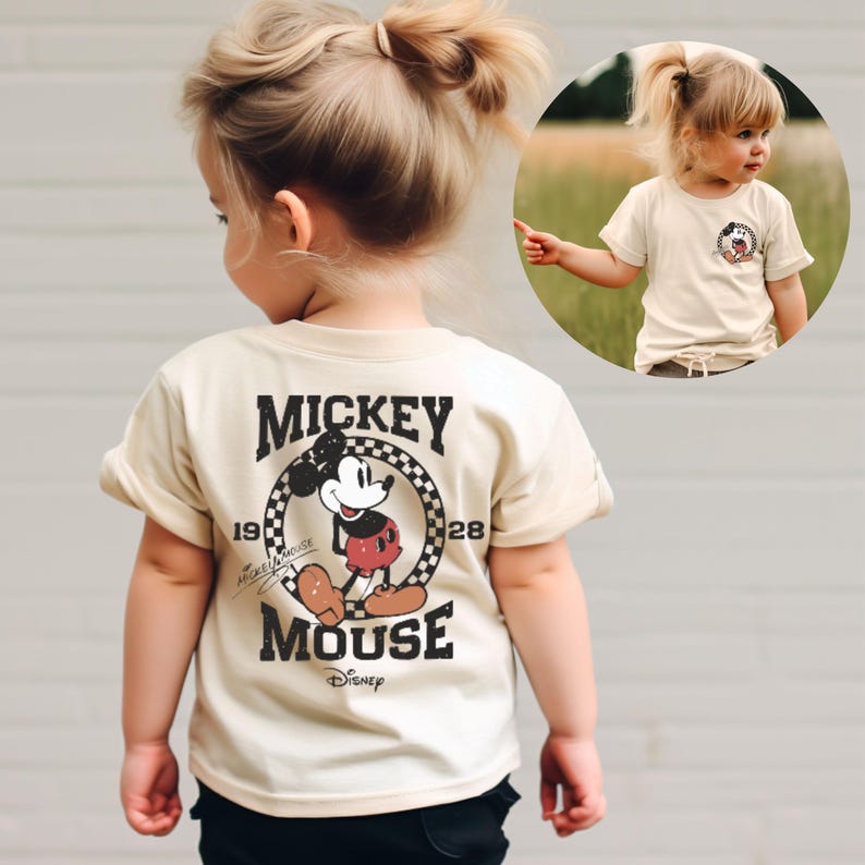 May include: A beige short-sleeved t-shirt with a vintage Mickey Mouse graphic on the back. The graphic features Mickey Mouse in a red and black outfit with the text "Mickey Mouse" and "Disney" in black.