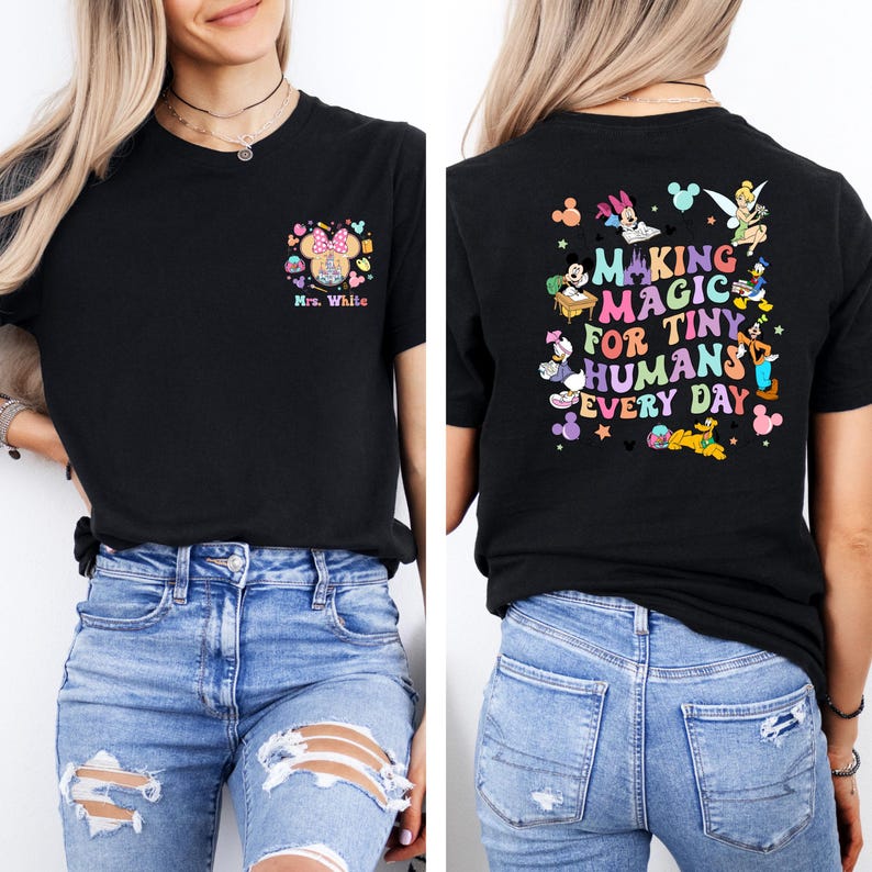 May include: Black t-shirt with a colorful graphic on the front and back. The front features a Minnie Mouse design with the text "Mrs. White." The back of the shirt says "Making Magic for Tiny Humans Every Day" with cartoon characters.