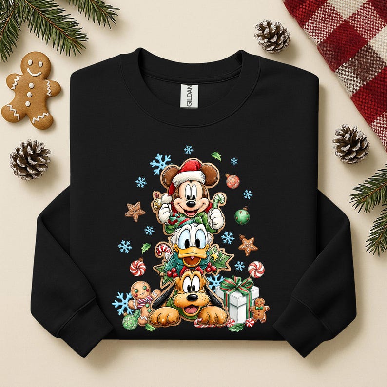 Peut inclure: Sweat-shirt noir avec Mickey Mouse, Donald Duck et Pluto empil&eacute;s, tous v&ecirc;tus pour No&euml;l. Le motif comprend des flocons de neige, des cannes en sucre et des bonhommes en pain d'&eacute;pices. V&ecirc;tements de vacances festifs.