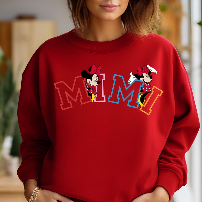 May include: Red sweatshirt with a colorful "MIMI" graphic featuring two cartoon mice. The mice are wearing red dresses with white polka dots and yellow shoes.
