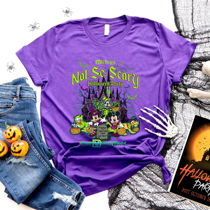 May include: Purple t-shirt with a graphic of Mickey Mouse and friends in front of a castle. The text "Mickey's Not-So-Scary Halloween Party" is on the shirt. The shirt also has the text "Walt Disney World".