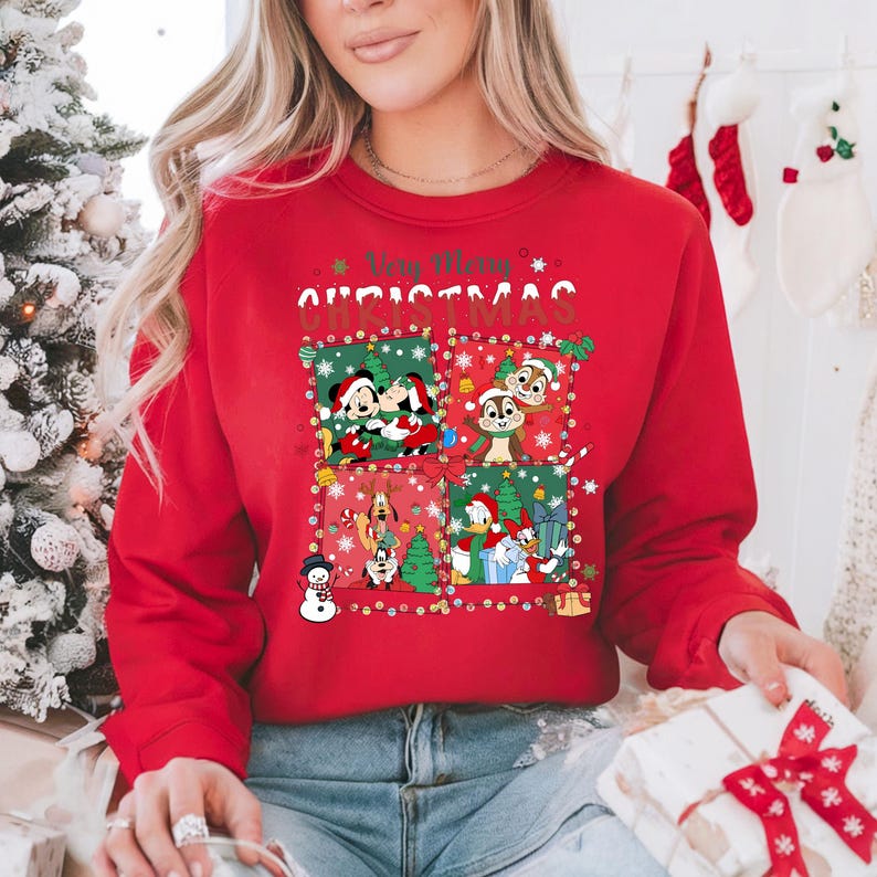 May include: Red Christmas sweatshirt featuring Mickey and Minnie Mouse, Chip and Dale, Goofy, Donald Duck, and other Disney characters. The words "Very Merry Christmas" are printed across the top in white and green.