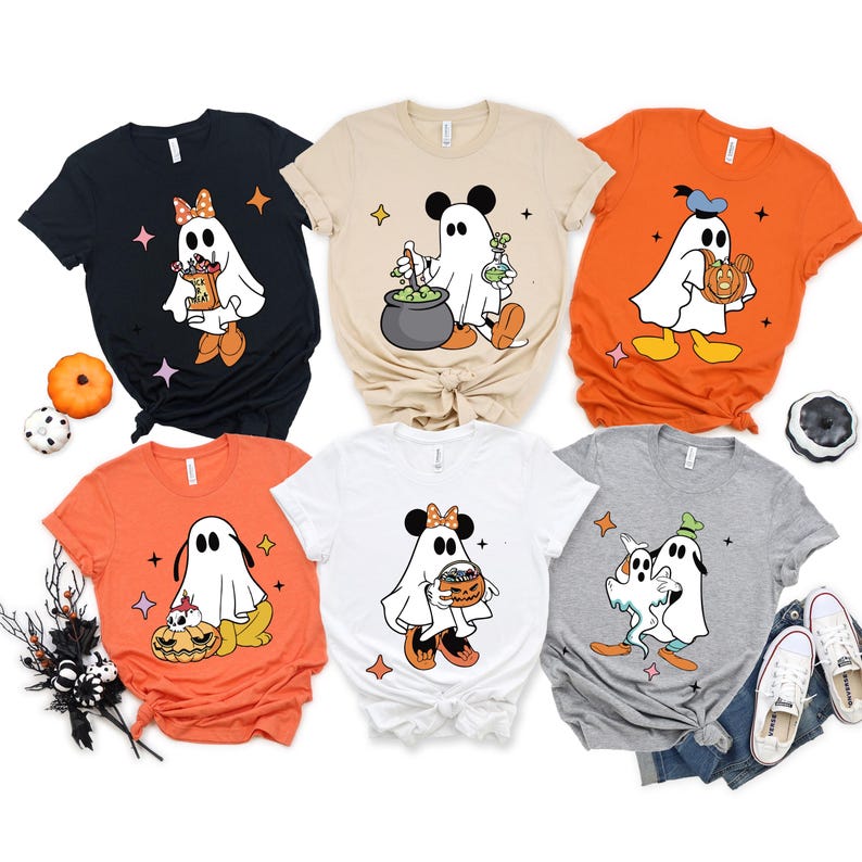 May include: A collection of six Halloween-themed t-shirts. Each shirt features a cartoon ghost character with Mickey Mouse ears and various Halloween props. The shirts are in black, beige, orange, white, and gray.