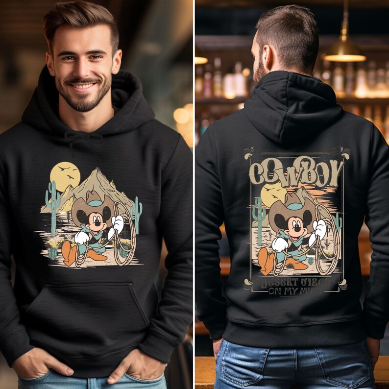 May include: Black hoodie with a vintage-style graphic of Mickey Mouse dressed as a cowboy. The graphic features Mickey Mouse wearing a cowboy hat and holding a lasso. The text "Cowboy" and "Desert vibes on my mind" are printed on the hoodie.