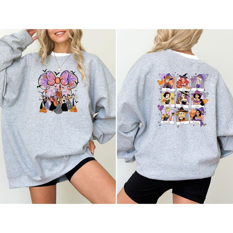 May include: A heather gray sweatshirt featuring a Halloween-themed graphic on the front and back. The front design includes a large bow with witch characters. The back displays nine framed witch portraits. A white crew neck is visible.
