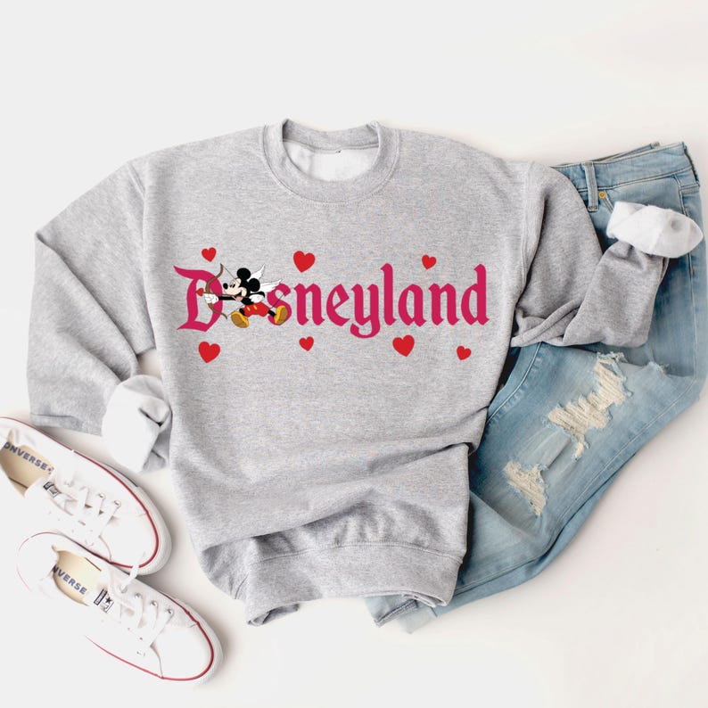 May include: Grey sweatshirt with a pink graphic of Mickey Mouse and the word "Disneyland" with red hearts.