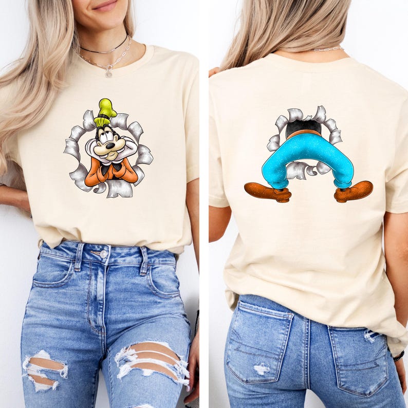 K&ouml;nnte beinhalten: Beiges T-Shirt mit einer Cartoonfigur, mit einem zerrissenen Papiereffekt. Die Vorderseite zeigt das Gesicht der Figur, w&auml;hrend die R&uuml;ckseite die Beine und F&uuml;&szlig;e der Figur zeigt. Die Figur tr&auml;gt einen gr&uuml;nen Hut, eine orangefarbene Weste und eine blaue Hose.