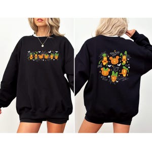 May include: Black sweatshirt with a white collar featuring Halloween-themed Mickey Mouse characters. The front has a row of pumpkins and the text "Boo!". The back displays Mickey Mouse, Goofy, and other characters in pumpkin form, with the text "Mickey Mouse".