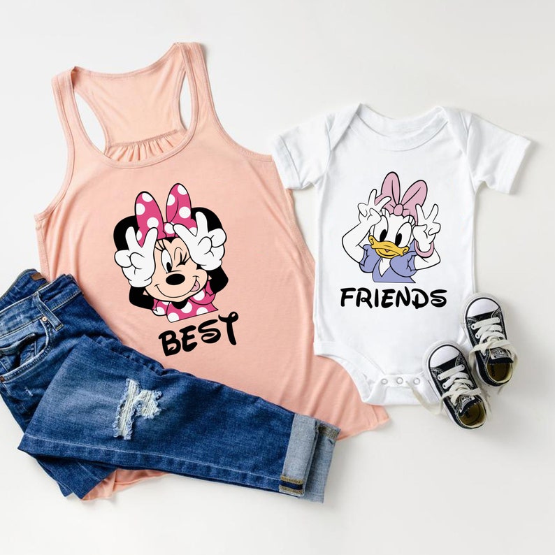Może przedstawiać: R&oacute;żowa koszulka na ramiączkach z kresk&oacute;wkowym wizerunkiem Minnie Mouse z napisem "BEST" oraz biały śpioszek z kresk&oacute;wkowym wizerunkiem Daisy Duck z napisem "FRIENDS".
