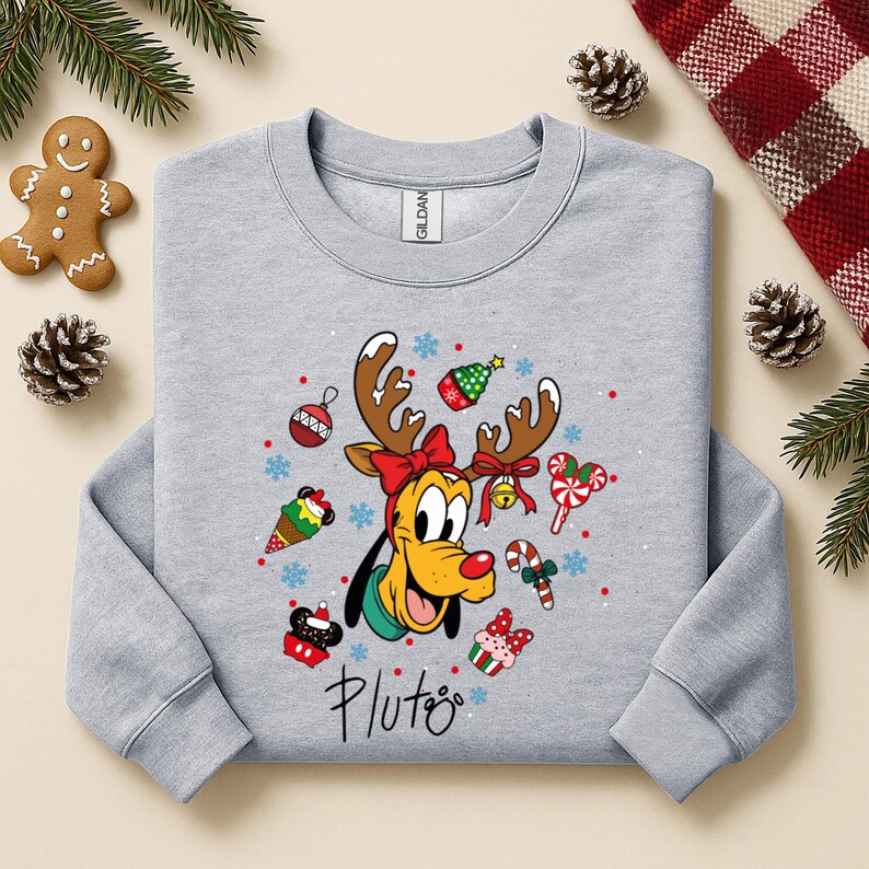 May include: A light gray sweatshirt featuring Pluto the dog with reindeer antlers and Christmas-themed decorations. The design includes a red bow, ornaments, and the word "Pluto" in script. Festive and seasonal.