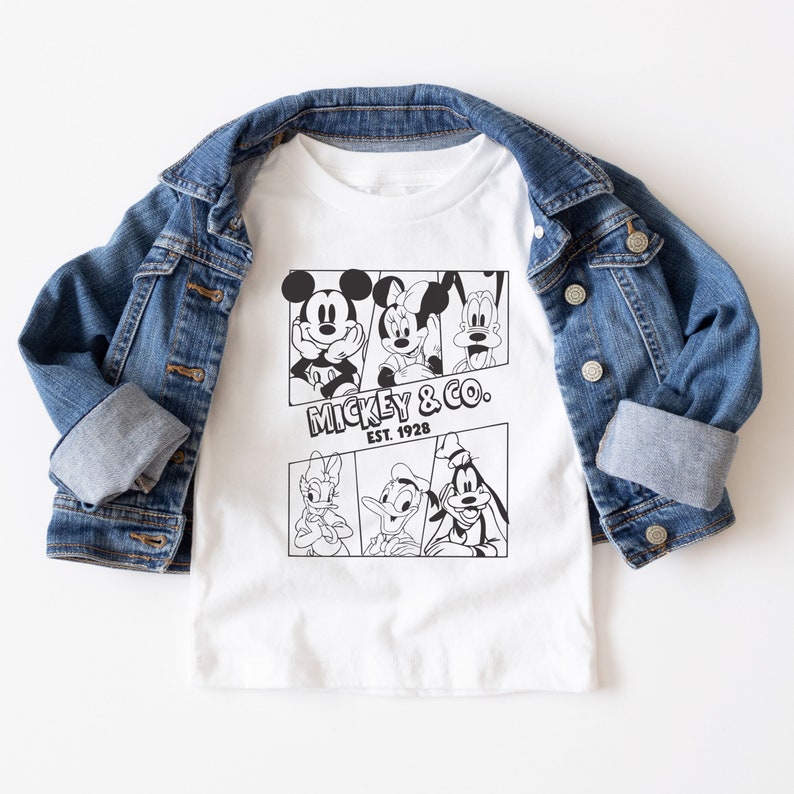 K&ouml;nnte beinhalten: Wei&szlig;es T-Shirt mit einem schwarz-wei&szlig;en Grafikdruck von Mickey Mouse, Minnie Mouse, Donald Duck und Goofy. Die Grafik zeigt die Figuren in Comic-Panels. Der Text "Mickey & Co. Est. 1928" ist unter der Grafik gedruckt.