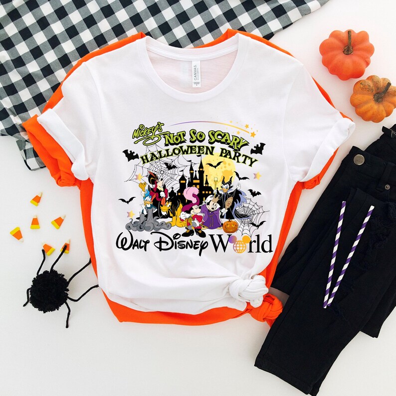 May include: White t-shirt with a graphic of Mickey Mouse and friends in a Halloween party setting. The text reads "Mickey's Not So Scary Halloween Party Walt Disney World".
