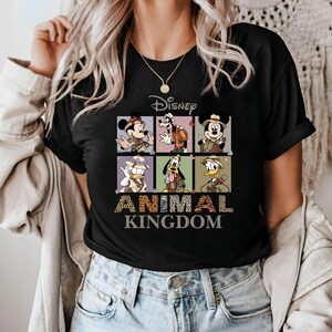 May include: Black t-shirt with a graphic of Disney characters dressed in safari outfits. The text "Disney Animal Kingdom" is printed below the graphic.