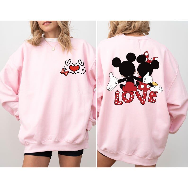 May include: Pink sweatshirt with a Mickey Mouse and Minnie Mouse graphic on the back that says "LOVE" and a graphic of Mickey Mouse and Minnie Mouse hands making a heart shape on the front.
